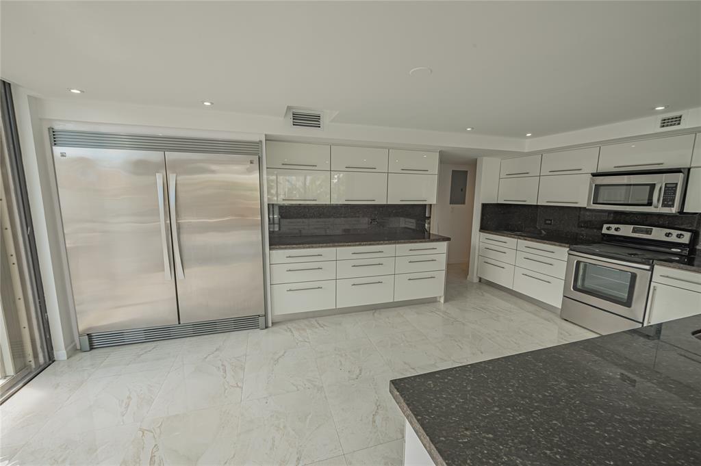 468 Golden Isles Drive, Unit 402 Hallandale Beach, FL 33009 - Photo 25 of 53 a kitchen with stainless steel appliances kitchen island a refrigerator sink and stove