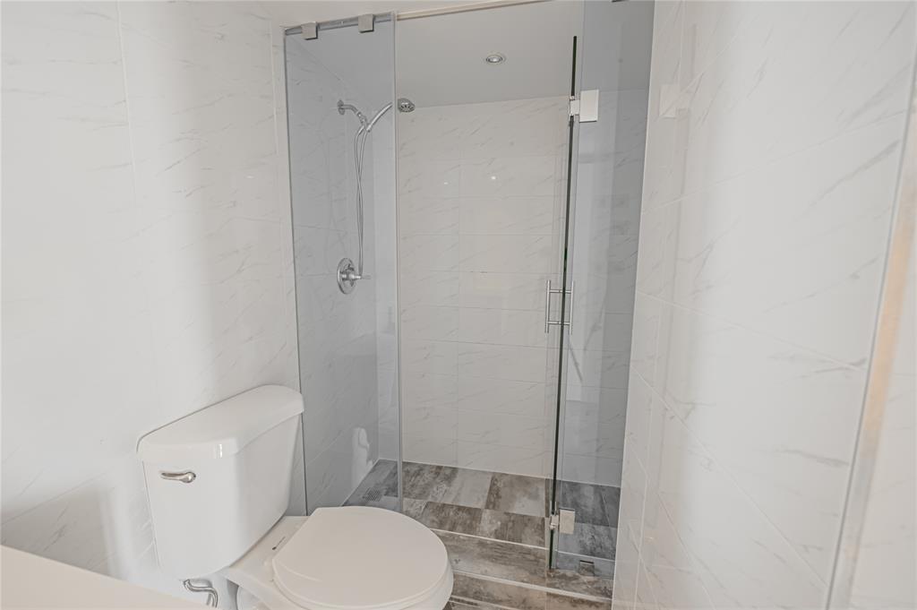 468 Golden Isles Drive, Unit 402 Hallandale Beach, FL 33009 - Photo 34 of 53 a white toilet sitting next to a bathroom sink