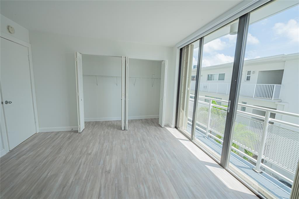468 Golden Isles Drive, Unit 402 Hallandale Beach, FL 33009 - Photo 37 of 53 a view of an empty room with wooden floor and a window