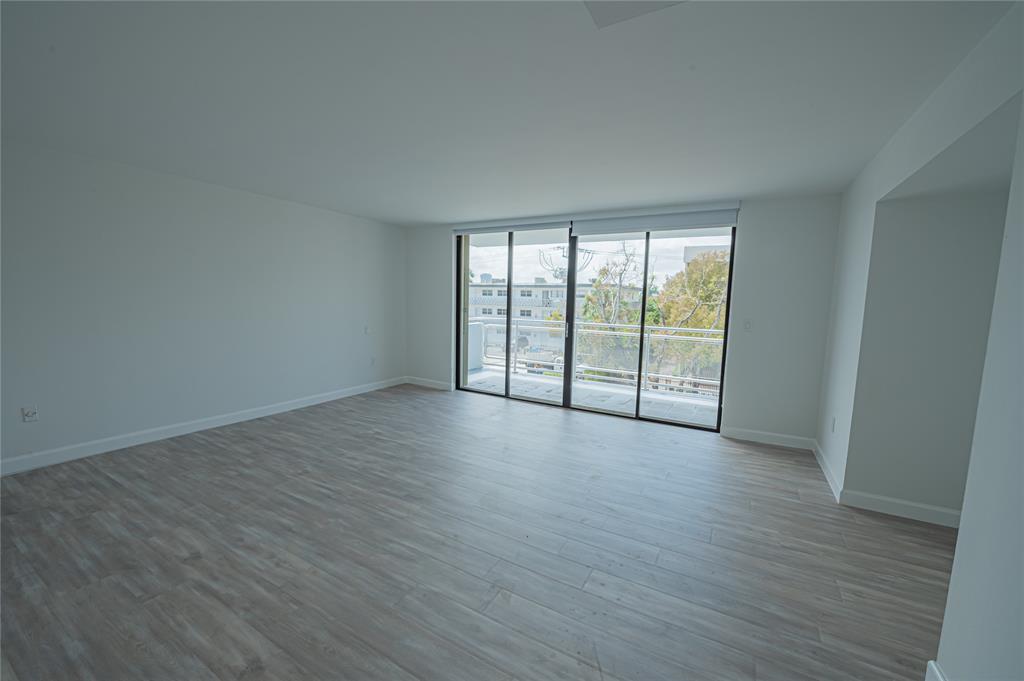 468 Golden Isles Drive, Unit 402 Hallandale Beach, FL 33009 - Photo 38 of 53 a view of an empty room with wooden floor and a window