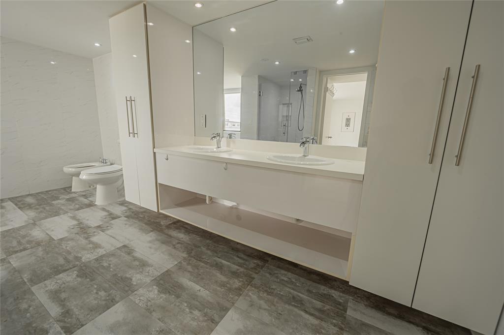 468 Golden Isles Drive, Unit 402 Hallandale Beach, FL 33009 - Photo 47 of 53 a bathroom with a sink a toilet and a large mirror