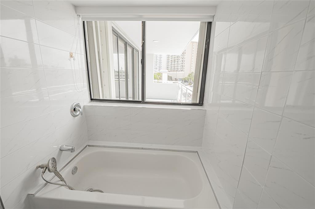 468 Golden Isles Drive, Unit 402 Hallandale Beach, FL 33009 - Photo 51 of 53 a white bath tub sitting next to a window