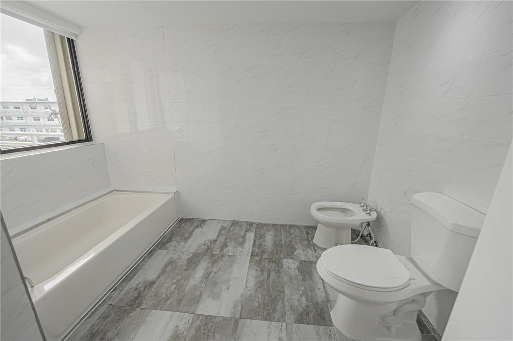 468 Golden Isles Drive, Unit 402 Hallandale Beach, FL 33009 - Photo 53 of 53 a white toilet sitting next to a bathroom sink