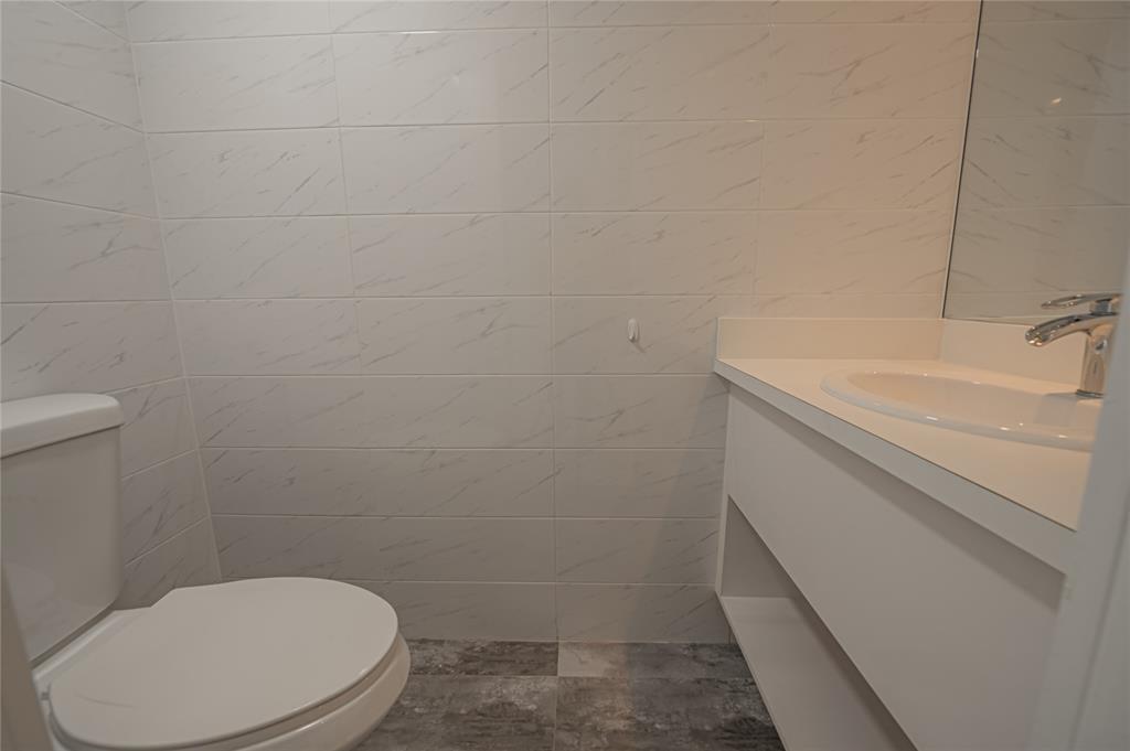 468 Golden Isles Drive, Unit 402 Hallandale Beach, FL 33009 - Photo 8 of 53 a bathroom with a toilet sink and vanity