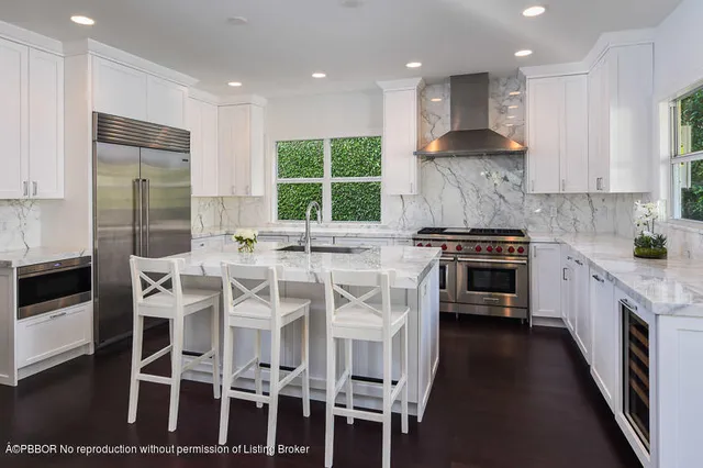 a kitchen with stainless steel appliances granite countertop a stove a sink a oven a dining table and chairs