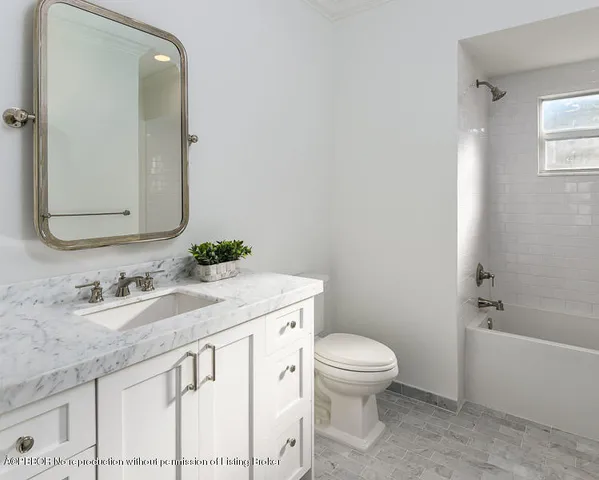 a bathroom with a granite countertop sink a toilet and a mirror