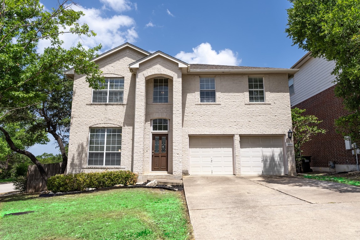 a front view of a house with a yard and garage