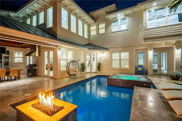 a view of a swimming pool with lawn chairs and floor to ceiling window