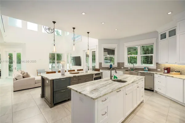 a large kitchen with kitchen island a large window in it