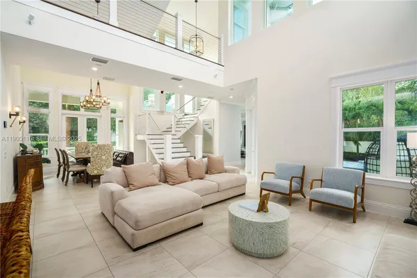 a living room with furniture kitchen view and a chandelier