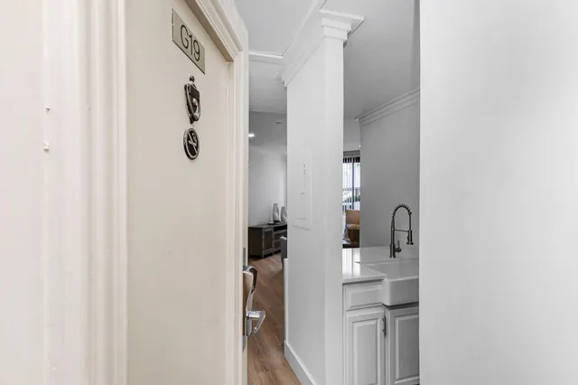 a view of a hallway with wooden floor and a living room