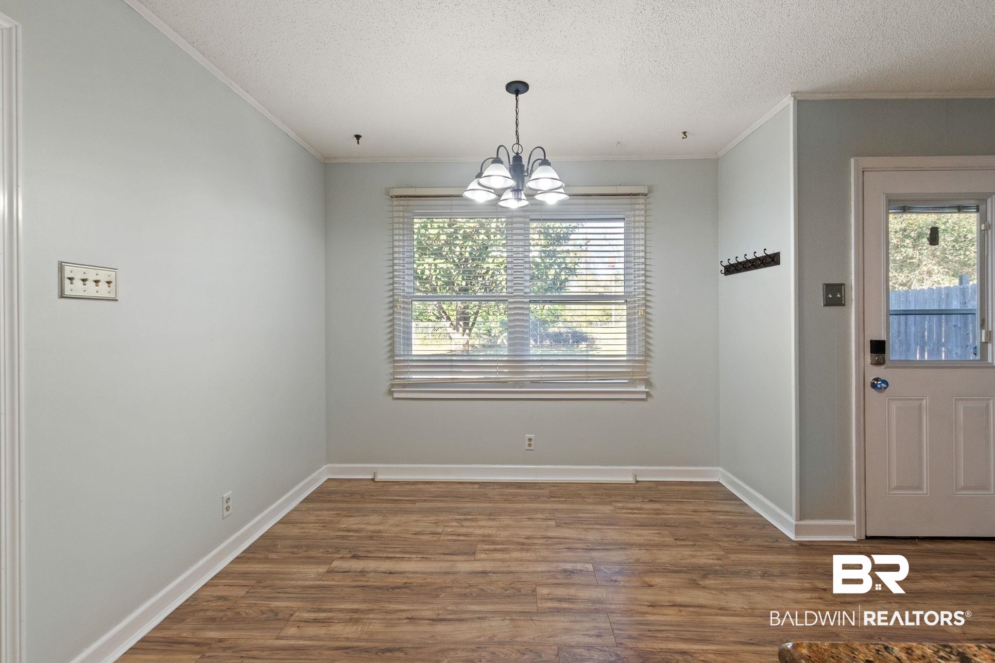 3864 Leroy Stevens Road Mobile, AL 36619 - Photo 12 of 33 Unfurnished dining area with dark wood-style flooring, a chandelier, a textured ceiling, and crown molding