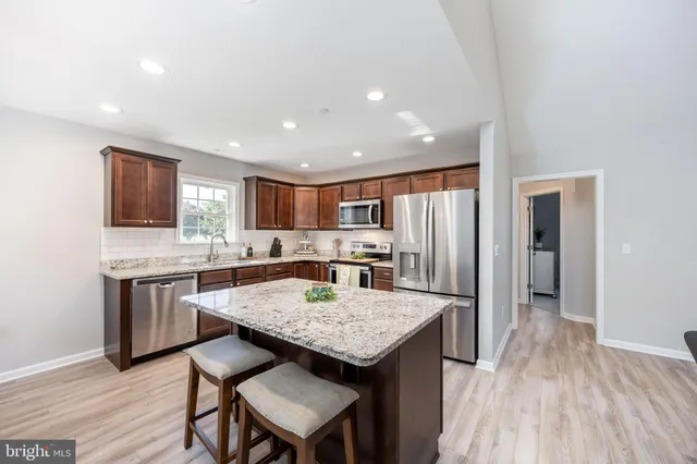 a kitchen with stainless steel appliances granite countertop a sink stove microwave and cabinets