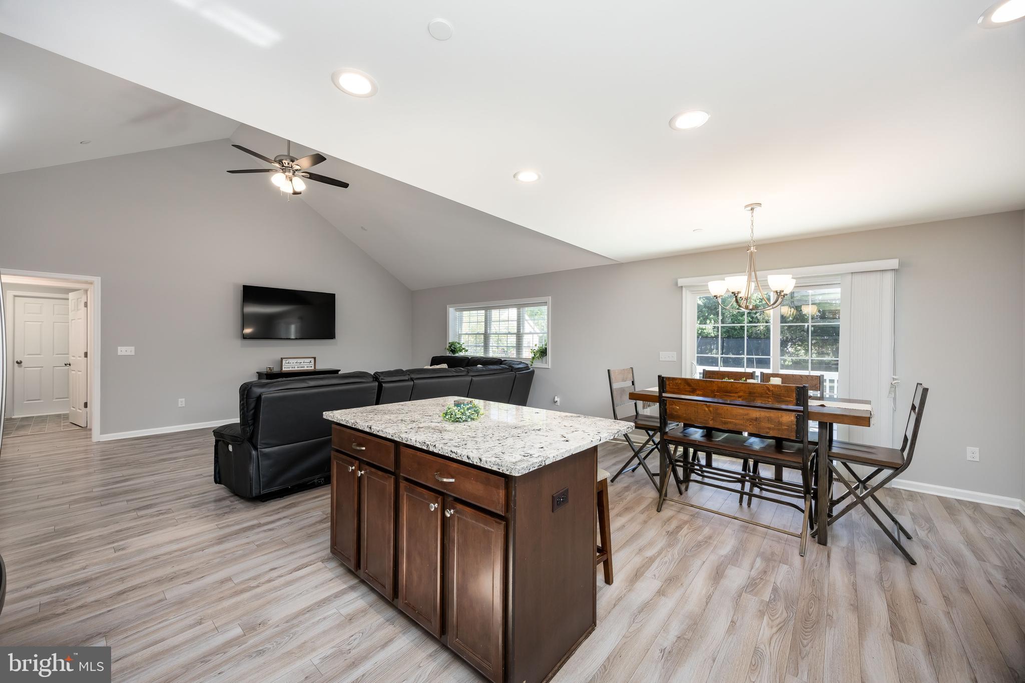 211 Moonglow Road Fruitland, MD 21826 - Photo 19 of 67 a kitchen with a stove a sink a dining table and chairs with wooden floor
