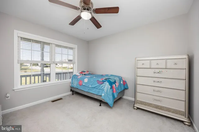 a bedroom with a bed and a flat tv screen on the dresser