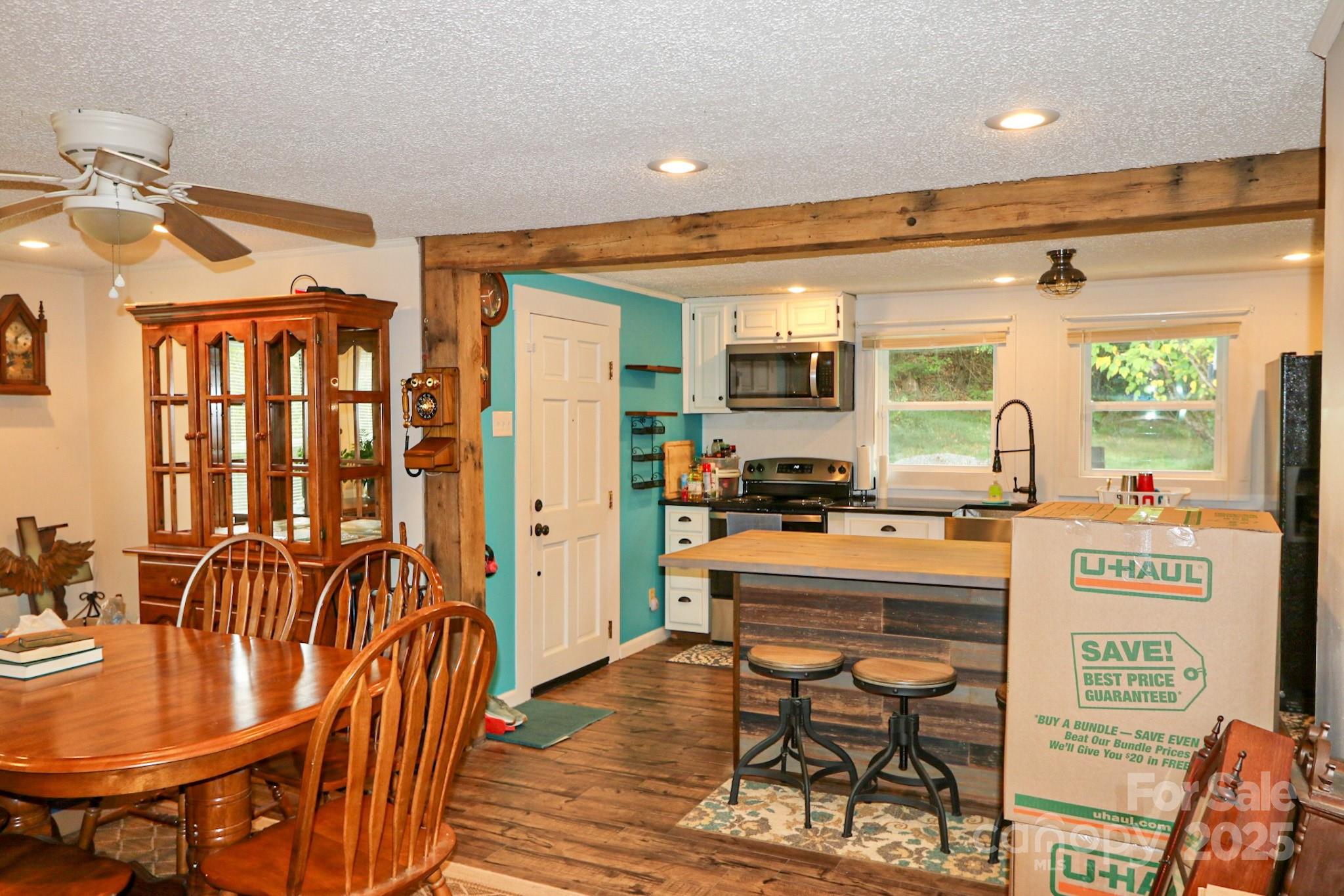 11979 Sparta Road McGrady, NC 28649 - Photo 17 of 48 a kitchen with stainless steel appliances granite countertop a stove a refrigerator a dining table and chairs with wooden floor