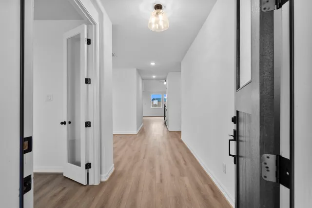 a view of a hallway with wooden floor and staircase
