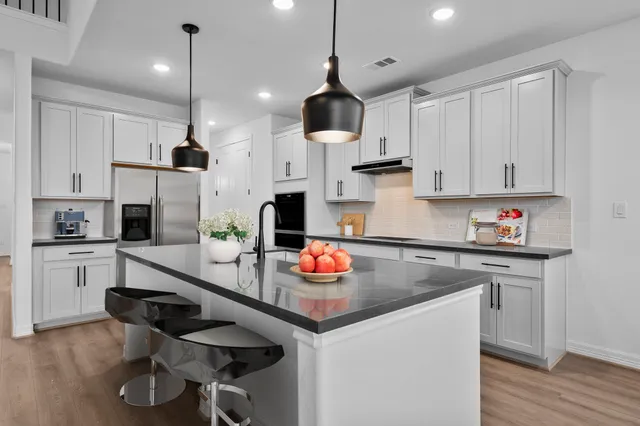 a kitchen with stainless steel appliances granite countertop a sink a stove and a refrigerator