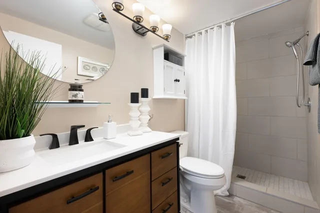 a bathroom with a sink a toilet and shower