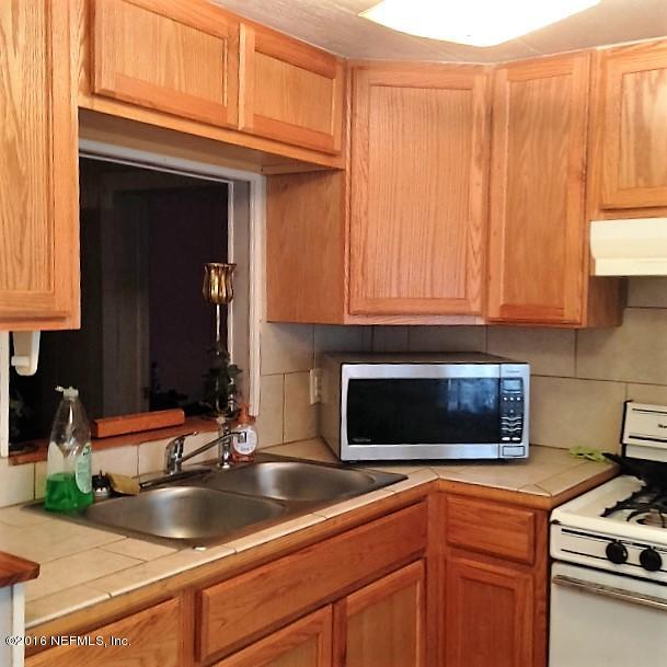 1535 Jake Road Jacksonville, FL 32226 - Photo 8 of 33 a kitchen with granite countertop a sink stove and cabinets