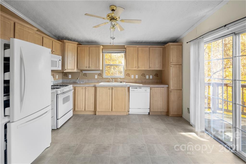 2226 Poplar Cove Road Clyde, NC 28721 - Photo 12 of 21 a kitchen with white cabinets and white appliances
