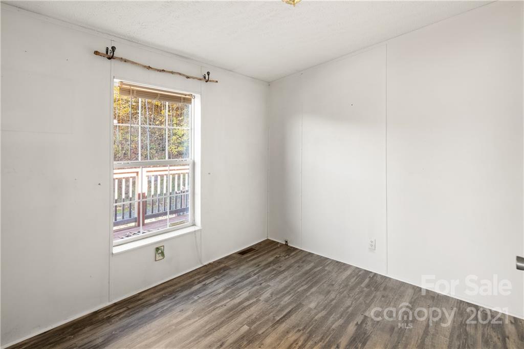 2226 Poplar Cove Road Clyde, NC 28721 - Photo 17 of 21 an empty room with wooden floor and windows
