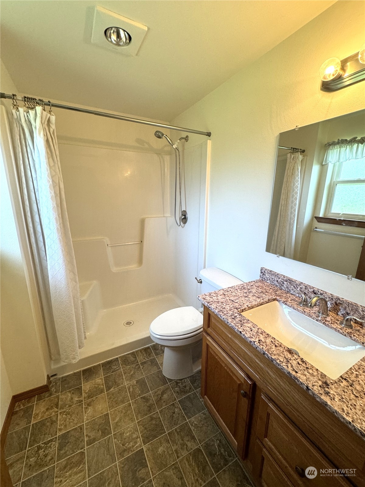 3274 East Harbor Road Langley, WA 98260 - Photo 15 of 21 a bathroom with a granite countertop sink toilet and shower