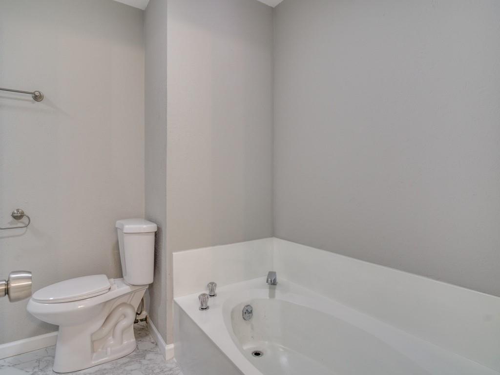 9523 Bellechase Road Granbury, TX 76049 - Photo 16 of 25 a white toilet sitting next to a white tub