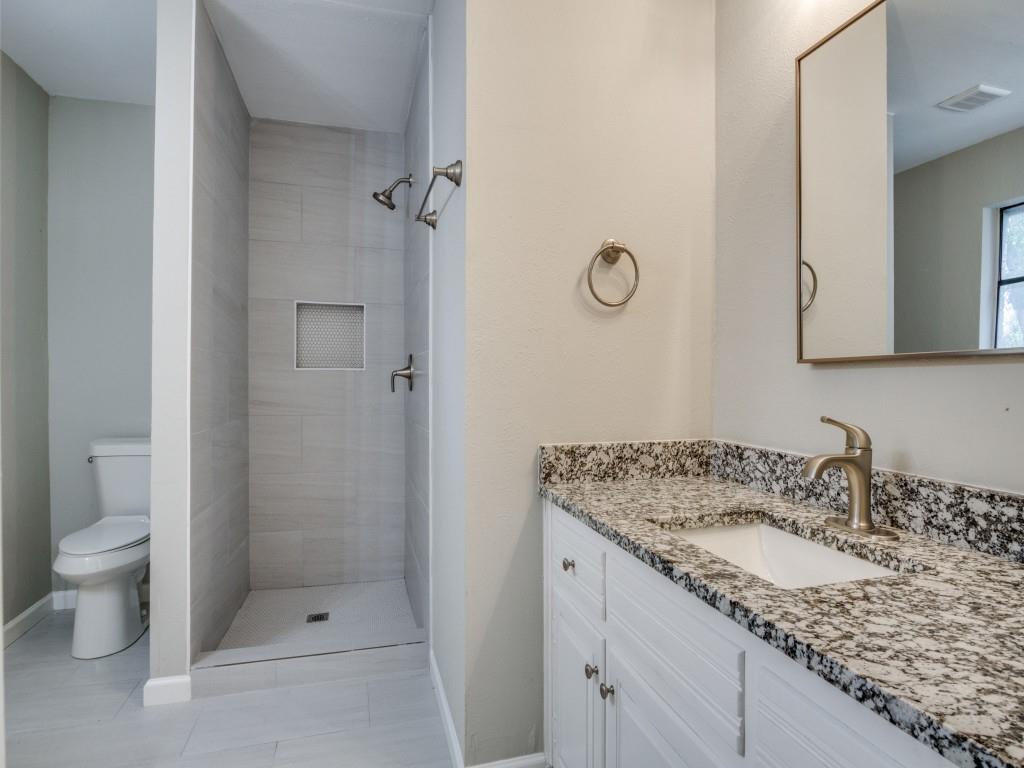 9523 Bellechase Road Granbury, TX 76049 - Photo 20 of 25 a bathroom with a granite countertop sink a toilet and shower