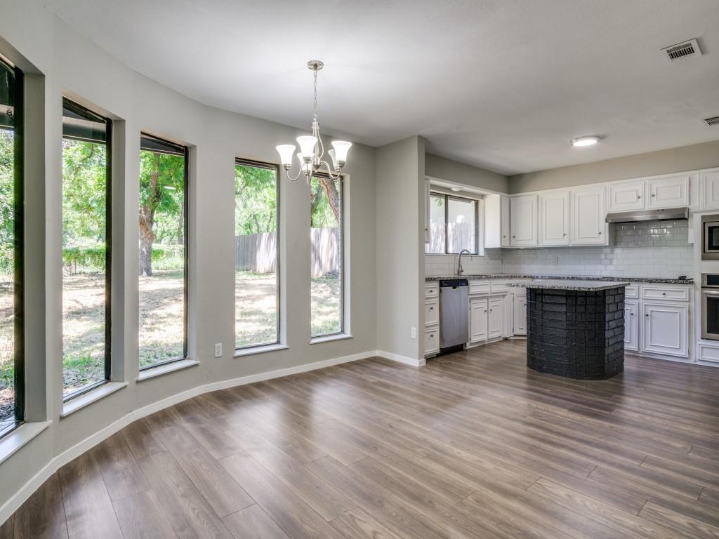 9523 Bellechase Road Granbury, TX 76049 - Photo 7 of 25 a view of a kitchen with a sink and dishwasher with wooden floor