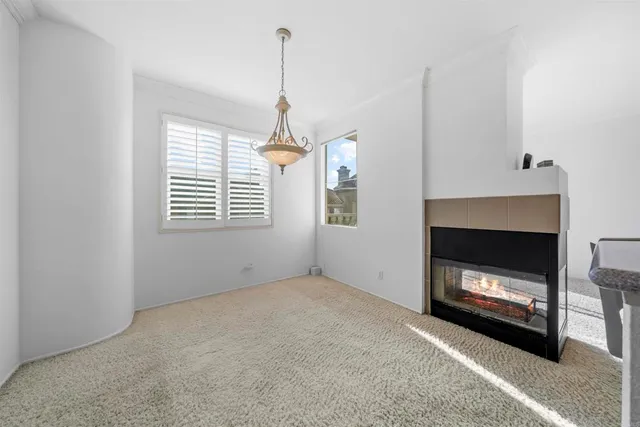 a view of an empty room with a fireplace and window