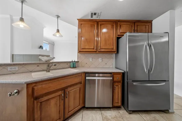 a kitchen with stainless steel appliances granite countertop a refrigerator a sink and a stove