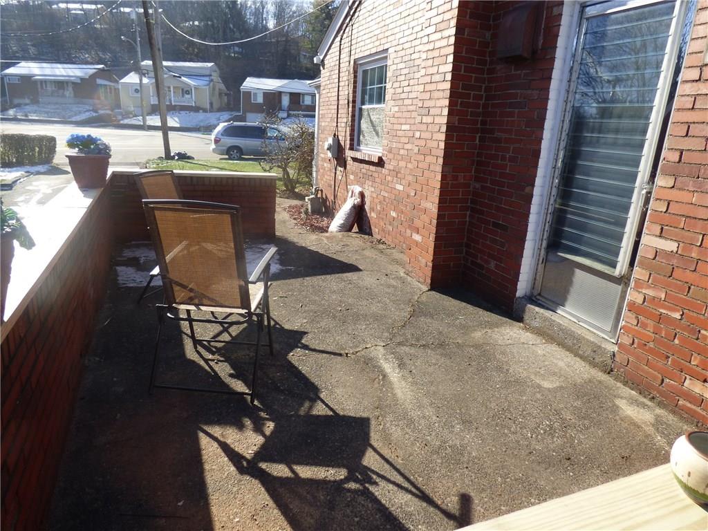 524 Scene Ridge Road Liberty, PA 15133 - Photo 15 of 23 Side porch, Concrete with door from kitchen, new treated wood top on a solid brick privacy wall. Awesome for relaxing in the sun or displaying your potted plants.