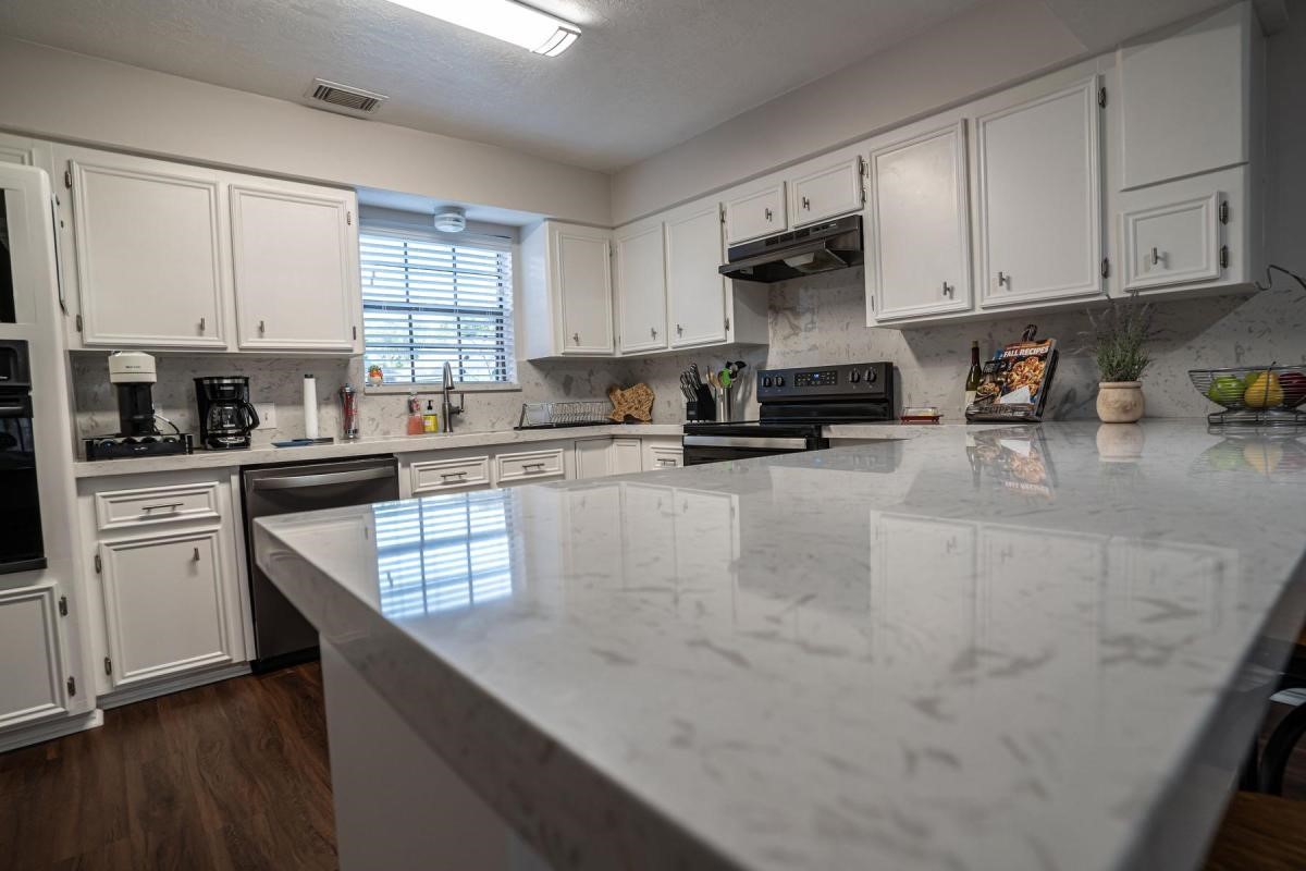 13209 Bluff View Drive Willis, TX 77318 - Photo 9 of 21 a kitchen with stainless steel appliances granite countertop a sink a stove and cabinets