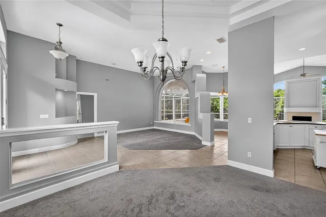 a view of a hallway with wooden floor a chandelier and entryway