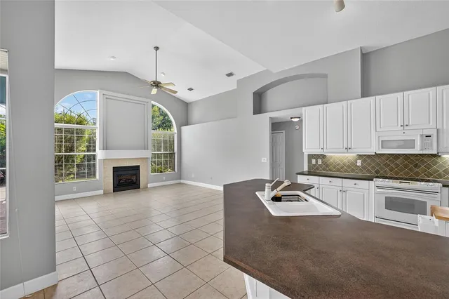 a kitchen with granite countertop a stove cabinets and microwave