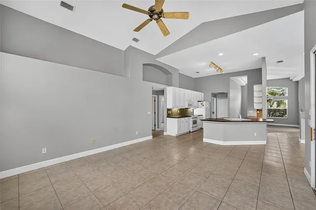 a open kitchen with stainless steel appliances granite countertop a stove a sink a counter space and cabinets