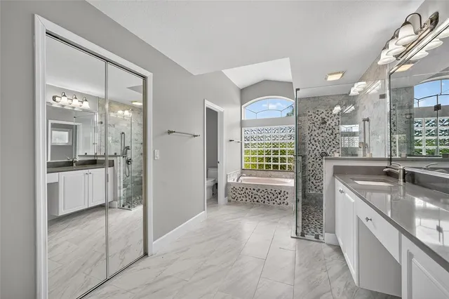 a large bathroom with a granite countertop sink a mirror and shower