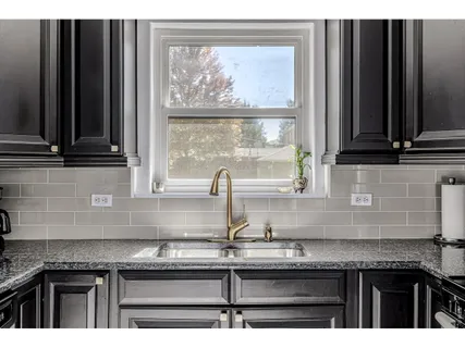 a kitchen with granite countertop a sink and a window