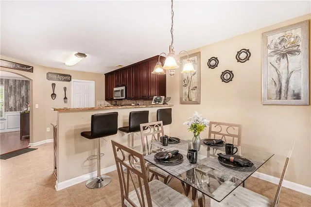 a kitchen with stainless steel appliances kitchen island granite countertop a table and chairs