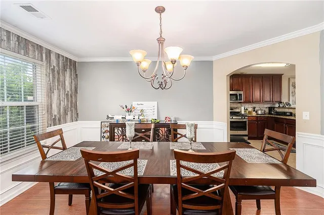 a view of a dining room with furniture a chandelier and wooden floor