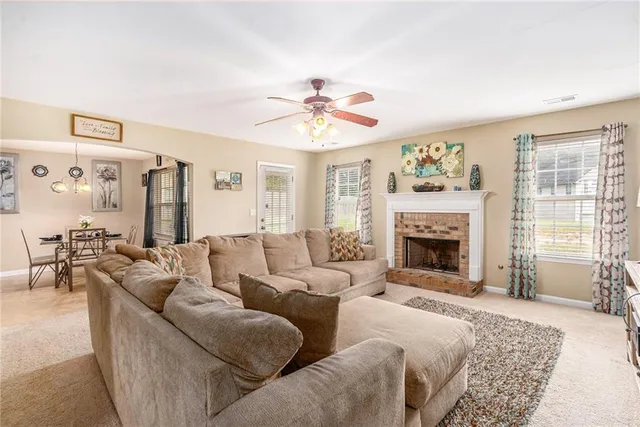 a living room with furniture a fireplace and a window