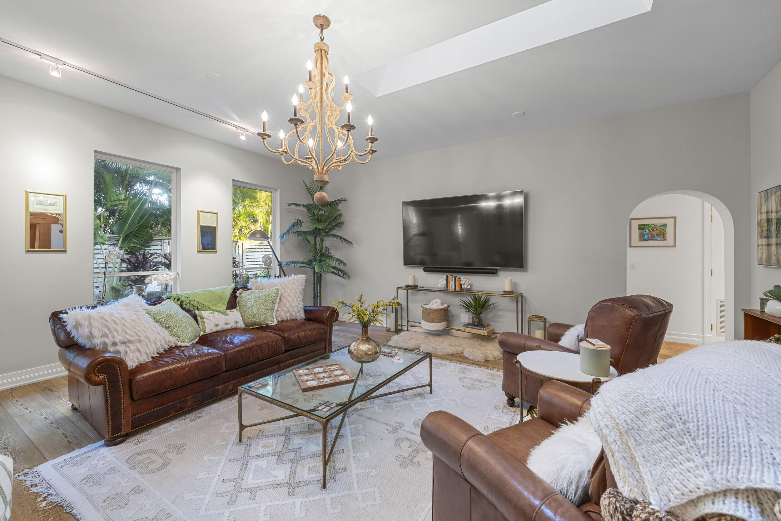 122 Lighthouse Drive Jupiter Inlet Colony, FL 33469 - Photo 11 of 84 a living room with furniture a chandelier and a flat screen tv