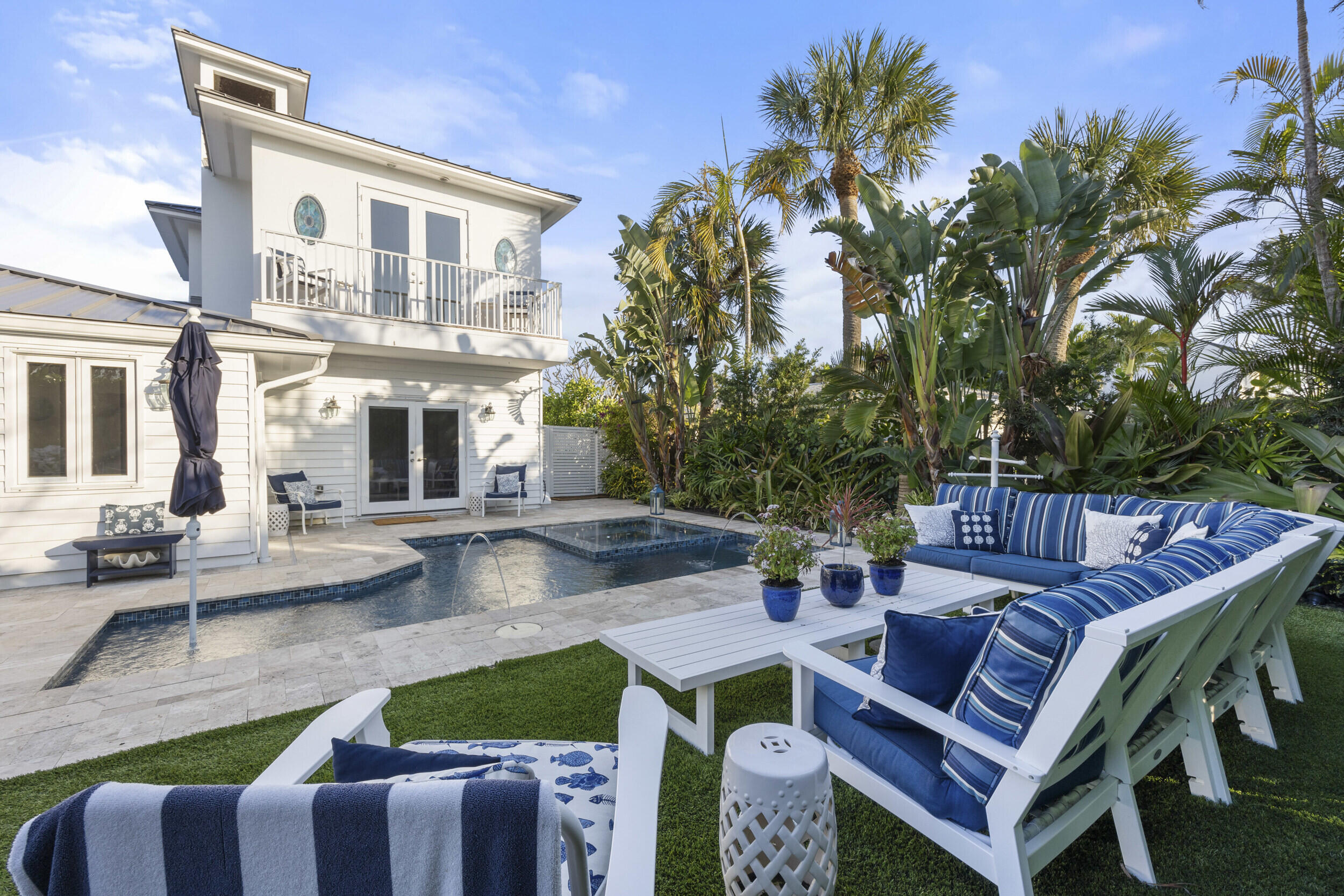 122 Lighthouse Drive Jupiter Inlet Colony, FL 33469 - Photo 59 of 84 a view of a patio with couches table and chairs and potted plants with wooden floor and fence