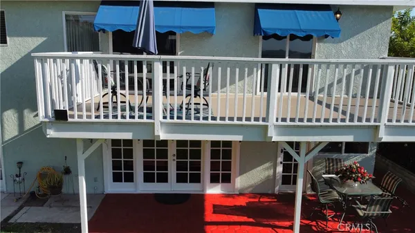 a view of a house with a deck and furniture