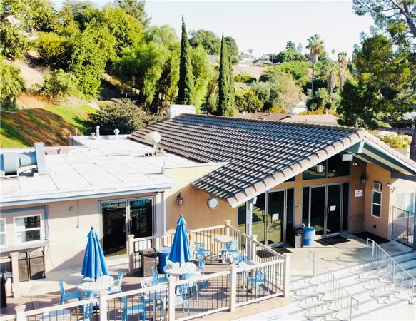 a view of a patio with table and chairs near a barbeque