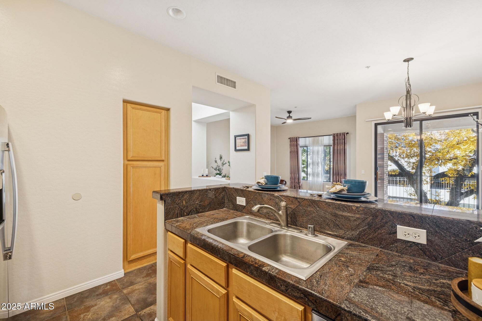 2989 North 44th Street, Unit 2023 Phoenix, AZ 85018 - Photo 5 of 20 a kitchen with granite countertop a sink and a refrigerator