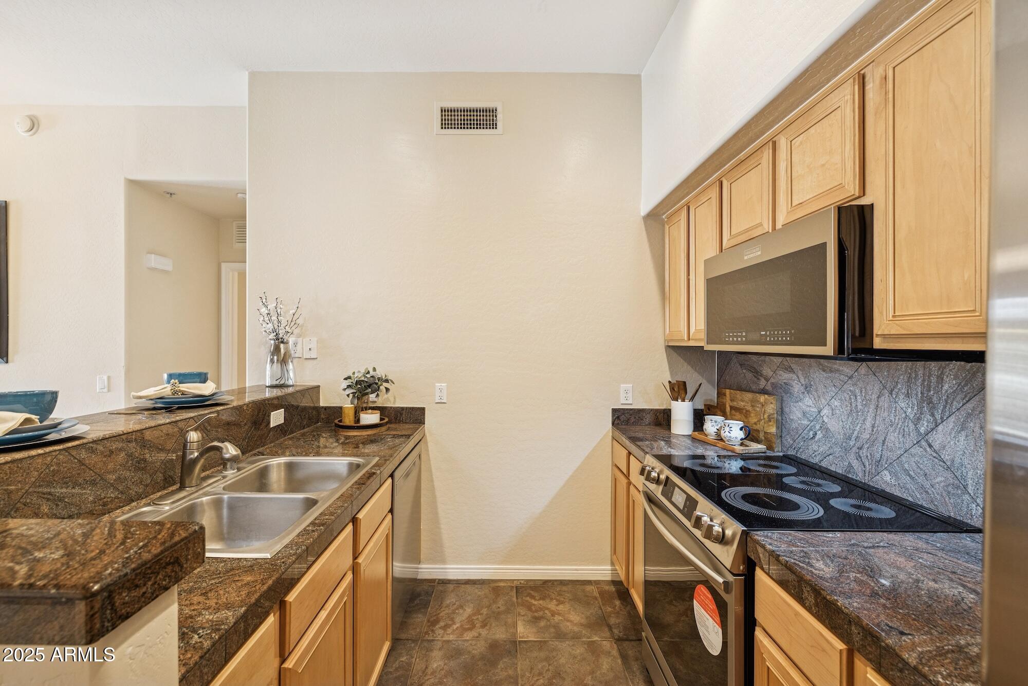 2989 North 44th Street, Unit 2023 Phoenix, AZ 85018 - Photo 9 of 20 a kitchen that has a sink and a stove