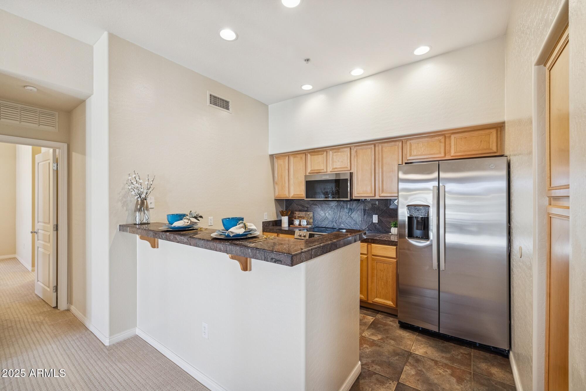 2989 North 44th Street, Unit 2023 Phoenix, AZ 85018 - Photo 10 of 20 a kitchen with stainless steel appliances granite countertop a refrigerator a sink and a stove