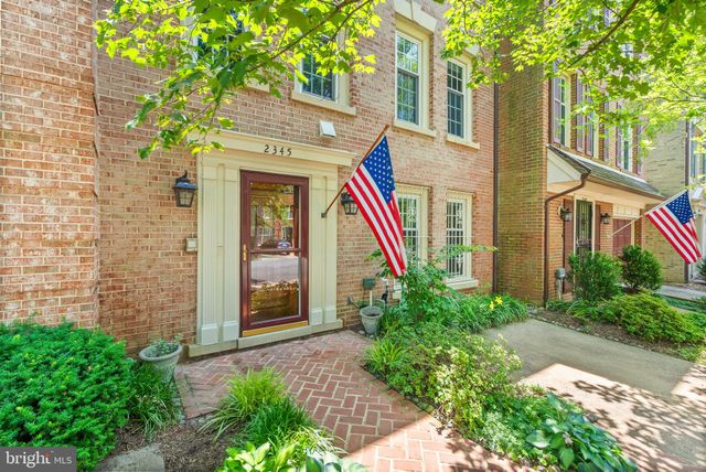 a view of a brick building next to a large tree